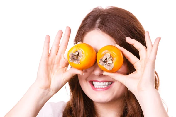 Женщина держит фрукты хурмы каки на глазах, изолированные — стоковое фото