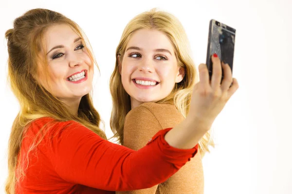スマートフォンを使って自分撮りをする2人の女性 — ストック写真