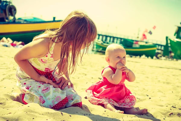 Девочка, веселящаяся с ребенком на пляже . — стоковое фото