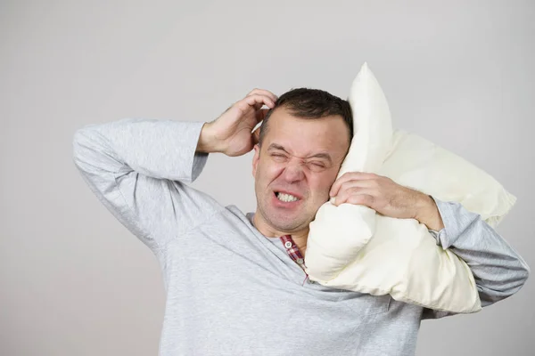 Hombre somnoliento cansado con almohada en gris —  Fotos de Stock