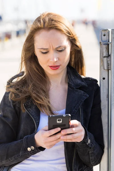 Meisje met mobiele telefoon tekstberichten op smartphone — Stockfoto