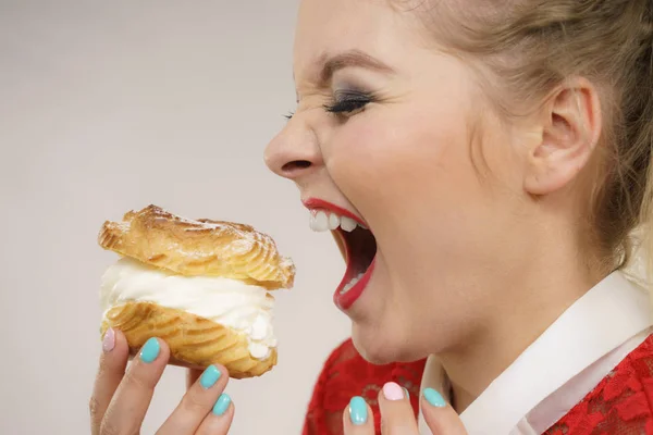 Funny woman holds cream puff cake — Stock Photo, Image