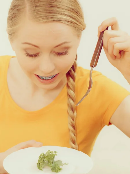 Jovem sorrindo mulher comendo alface — Fotografia de Stock