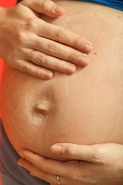 Gravid kvinna att ha grädde på stor mage — Stockfoto