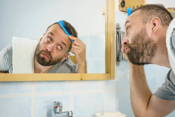 Man met kam in badkamer — Stockfoto