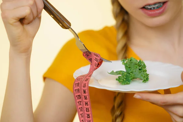 Woman on diet holding plate with lettuce — Stock Photo, Image