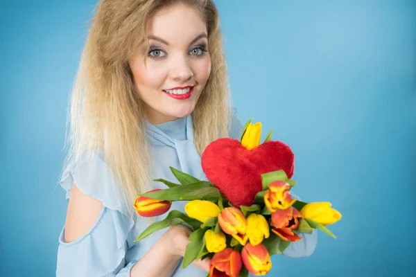 Mulher segura tulipas e coração vermelho — Fotografia de Stock