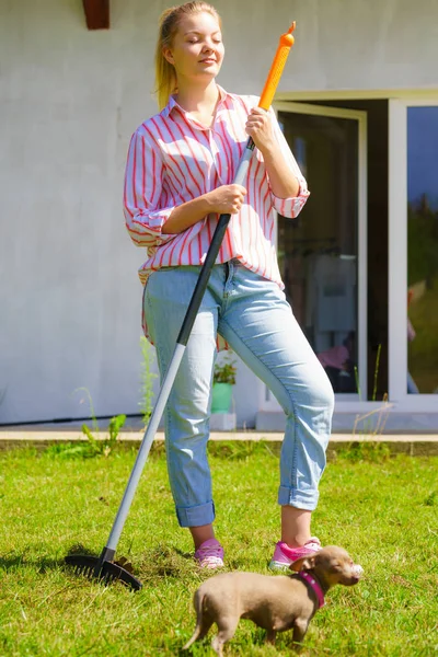 Mujer usando rastrillo para limpiar el jardín — Foto de Stock