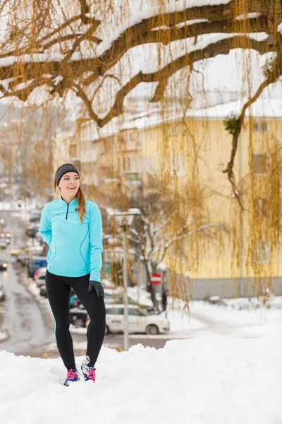 Menina de pé, vestindo sportswear inverno, fundo urbano — Fotografia de Stock