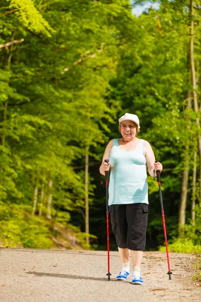 Femme âgée pratiquant la marche nordique dans le parc — Photo