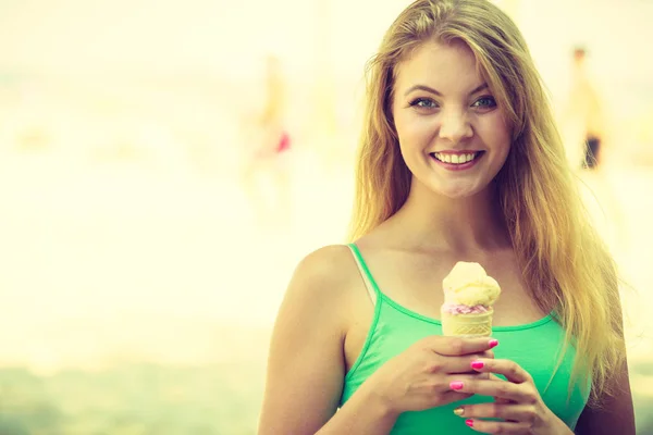 Szczęśliwa kobieta jedzenie lody na plaży — Zdjęcie stockowe