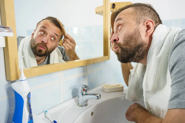 Hombre usando peine en el baño —  Fotos de Stock