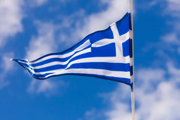 Griekse vlag zwaaien tegen blauwe hemel — Stockfoto
