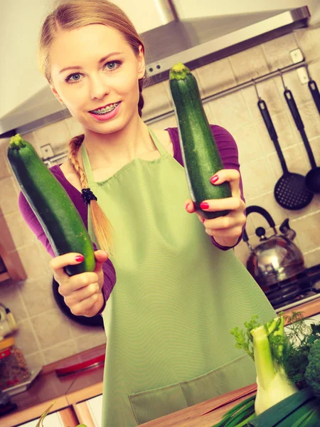 Donna in cucina tiene zucchine vegetali — Foto Stock