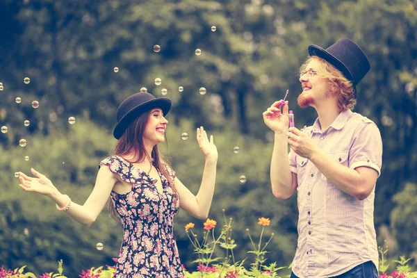 Paar blowing belletjes buiten — Stockfoto