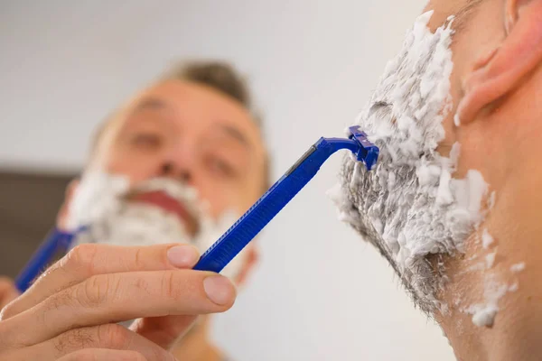 Tipo afeitándose la barba en el baño — Foto de Stock