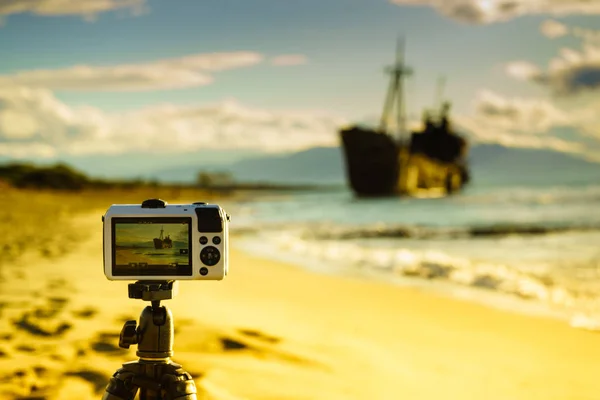 Camera on tripod and shipwreck — Stock Photo, Image