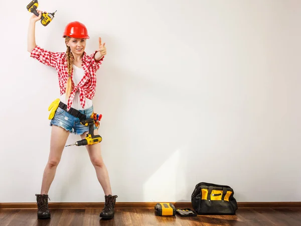 Frau mit Helm, Werkzeuggurt vor der Bohrwand — Stockfoto