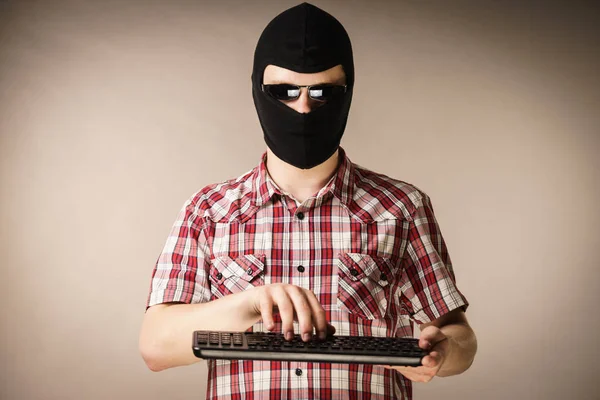 Man dragen balaclava bedrijf toetsenbord — Stockfoto