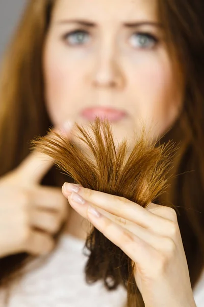 Femme inquiète regardant ses cheveux secs se termine — Photo