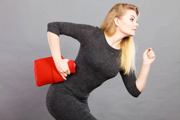 Frau hält warme rote Wärmflasche in der Hand — Stockfoto