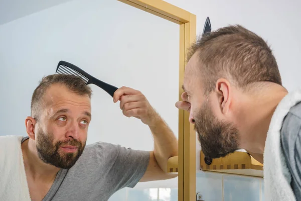 Homem usando pente no banheiro — Fotografia de Stock