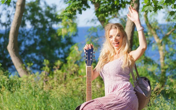 Kobieta gra na gitarze akustycznej w parku — Zdjęcie stockowe