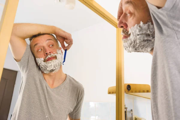Guy scheren van zijn baard in badkamer — Stockfoto