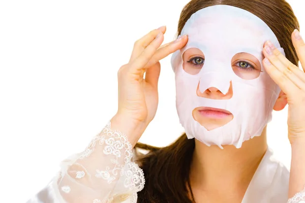 Woman applying sheet mask on face — Stock Photo, Image