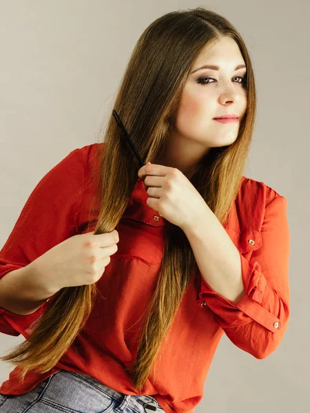 Mulher penteando seu cabelo castanho — Fotografia de Stock