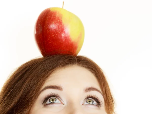 Vrouw houdt op hoofd appel fruit op zoek omhoog — Stockfoto