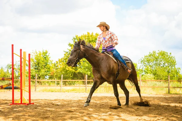 Cowgirl i västra hatt gör hästhoppning — Stockfoto