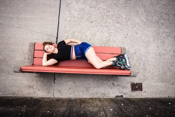 ローラー スケートを着てベンチに狂った女 — ストック写真