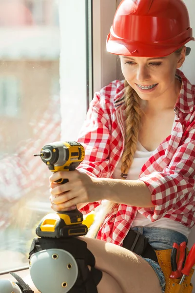 Woman wearing helmet using drill — Stock Photo, Image