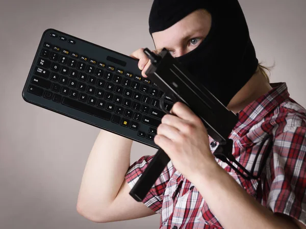 Man in balaclava holding keyboard and gun — Stock Photo, Image