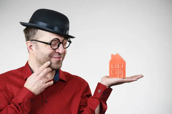 Man wearing funny eyeglasses holding house — Stock Photo, Image