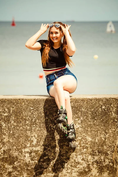 Happy young woman wearing roller skates — Stock Photo, Image