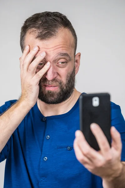Homme adulte inquiet regardant smartphone — Photo