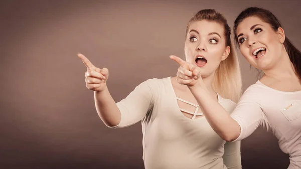 Mujeres felices señalando con un dedo . — Foto de Stock