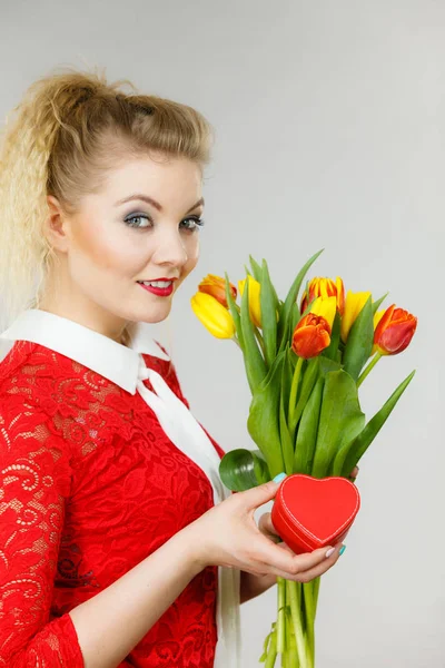 Vrouw bedrijf tulpen en cadeau — Stockfoto