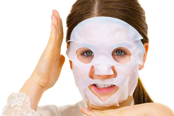 Woman applying sheet mask on face — Stock Photo, Image