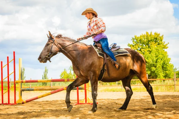 Vaquera en sombrero occidental haciendo salto de caballo — Foto de Stock