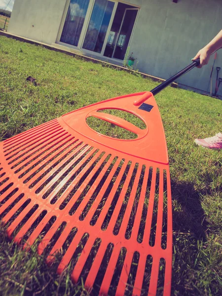 Unusual angle of woman raking leaves — Stock Photo, Image