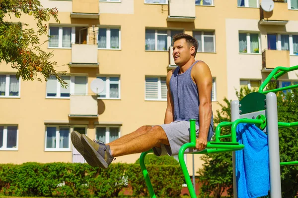 Hombre haciendo sit ups en el gimnasio al aire libre — Foto de Stock