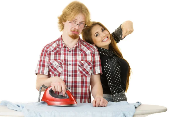 Щаслива жінка і нудний чоловік прасують одяг — стокове фото