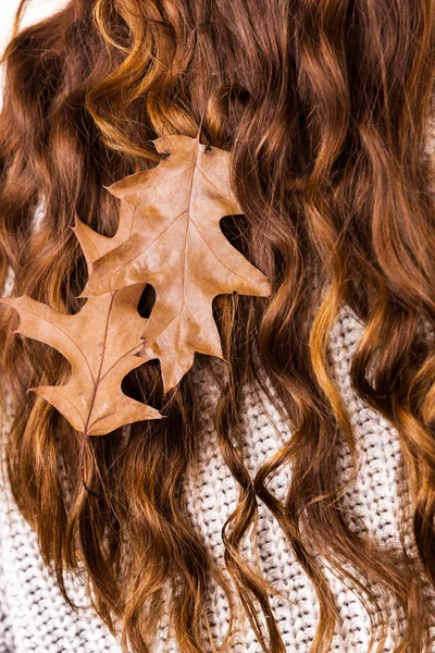 Woman with autumn leaves in long brown hair — Stock Photo, Image