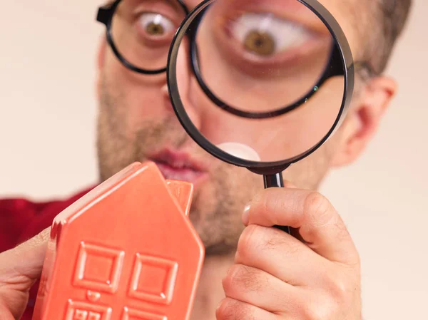 Man magnifying red house — Stock Photo, Image