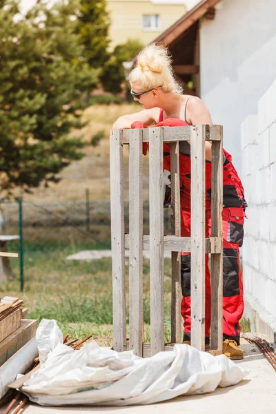 Vrouw in tuinbroek werken op de bouwplaats — Stockfoto