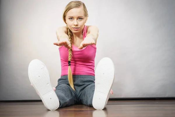 Vrouw in sportkleding zittend op grond — Stockfoto