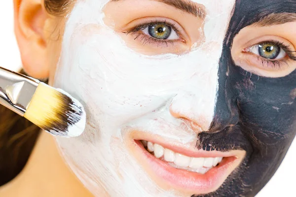 Chica máscara negra en media cara aplicar barro blanco —  Fotos de Stock